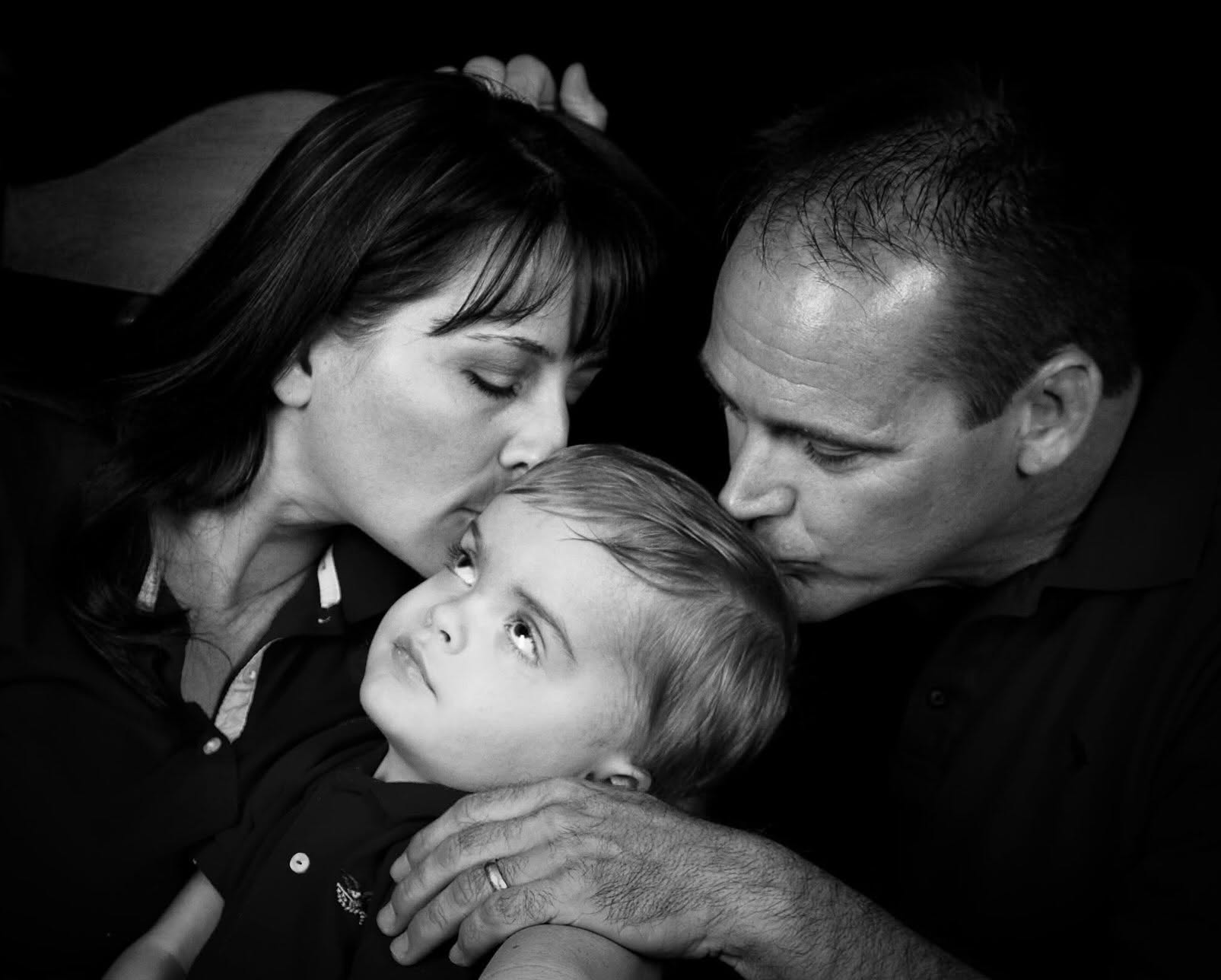Dave Ogden and his wife sharing a tender moment with their child